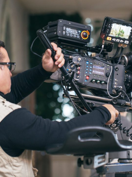 Camera operator with modern professional equipment working during film shooting